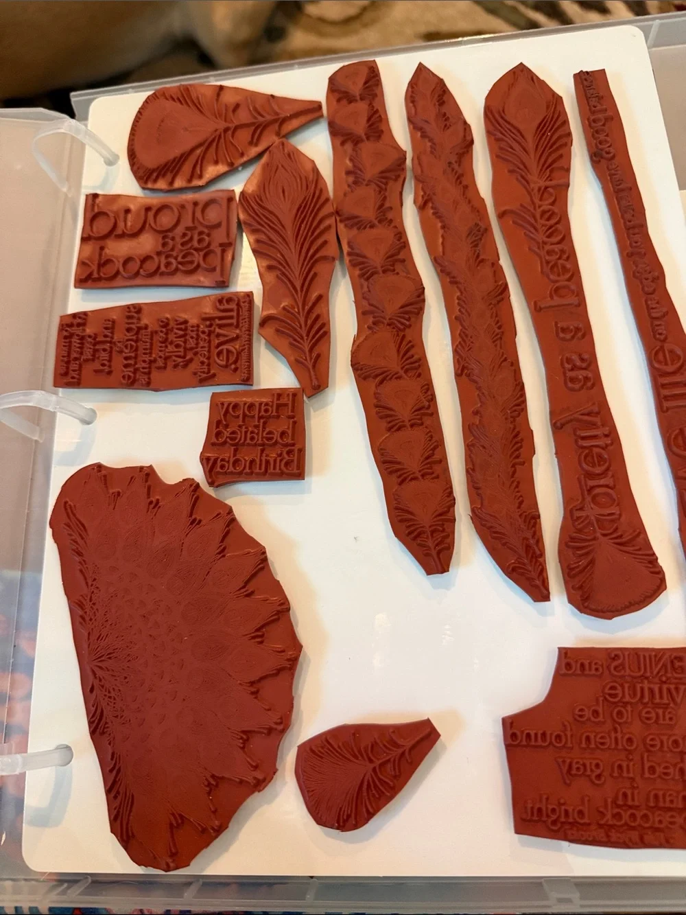 Set of 7  Peacock Feather and Script Stamps in a plastic binder by Club scrap